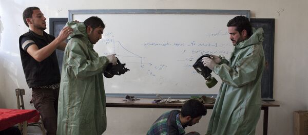 Aleppo University student, shows Syrian citizens hows to put protective gear as he instructs them with rudimentary means of how to respond to a chemical attack, in the northern Syrian city of Aleppo (File) - Sputnik International