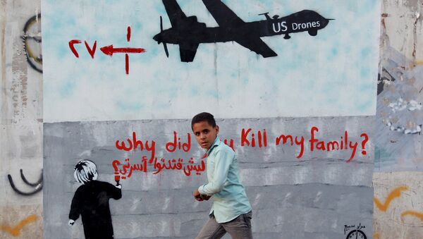 A Yemeni boy (C) walks past a mural depicting a US drone and reading  Why did you kill my family on December 13, 2013 in the capital Sanaa. - Sputnik International