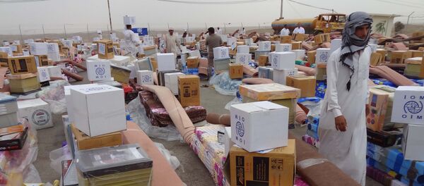 Iraqi men collect humanitarian aid supplies provided by the US development agency USAID to displaced Iraqis who have fled clashes between Islamic State group jihadists and Peshmerga fighters, on October 2, 2014, in the town of Daquq, around 180 kilometres (110 miles) north of Baghdad - Sputnik International