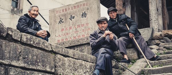 Old men hanging out at the entrance to covered wooden bridge built in the Ming Dynasty in a small town in Zhejiang Province, China Old men hanging out at the entrance to covered wooden bridge built in the Ming Dynasty in a small town in Zhejiang Province, China - Sputnik International