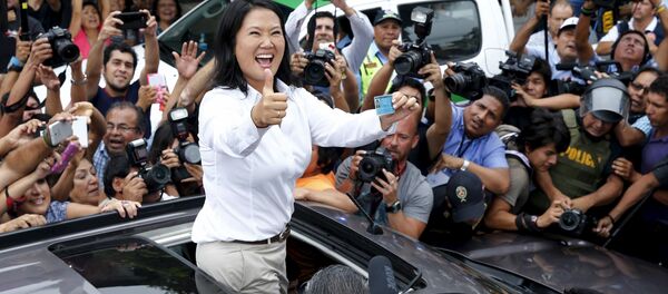 Peru's presidential candidate Keiko Fujimori gestures to supporters and media as she holds her I.D. after voting during presidential election in Lima, Peru, April 10, 2016. - Sputnik International