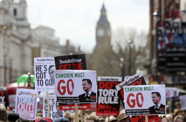 Demonstrators hold placards during a protest outside Downing Street in Whitehall, central London, Britain April 9, 2016.  - Sputnik International