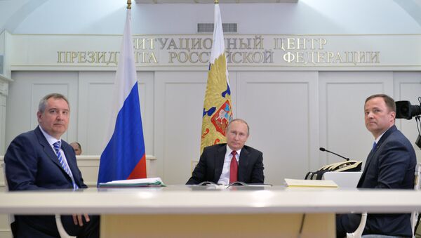 Russian President Vladimir Putin, center, Deputy Prime Minister Dmitry Rogozin, left, and Igor Komarov, General Director of the Roscosmos State Corporation for Space Activities, take part in a videoconference with the International Space Station and the Vostochny space center at the situation center in the Kremlin. - Sputnik International