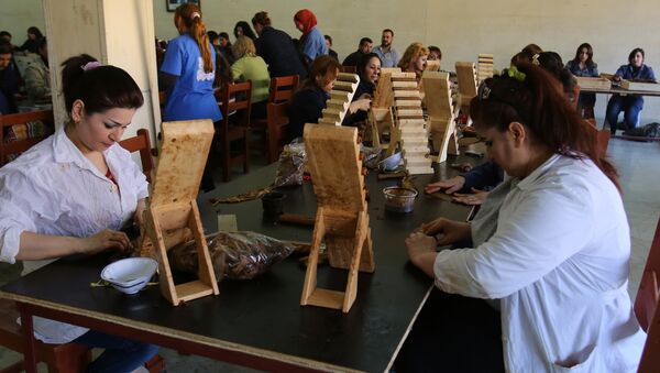 Syrian employees work at the production of Syria's first locally made cigars at a factory in the northeastern province of Latakia - Sputnik International