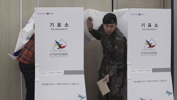 A South Korean army soldier comes out of a booth to cast his preliminary vote for the upcoming parliamentary election at a local polling station in Seoul. - Sputnik International