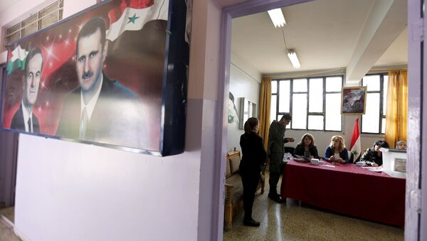 A banner showing Syria's president Bashar al-Assad and his father, former president Hafez al-Assad is seen inside a polling station during the parliamentary elections in Damascus, Syria - Sputnik International