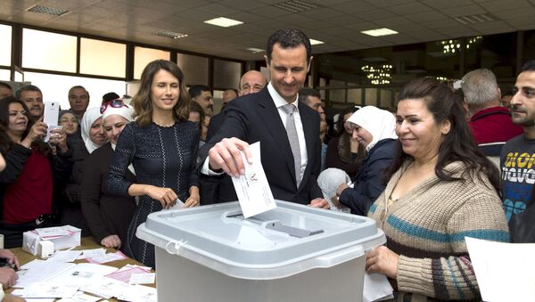 Syria's President Bashar al-Assad (C) casts his vote next to his wife Asma (centre left) inside a polling station during parliamentary elections in Damascus, Syria - Sputnik International