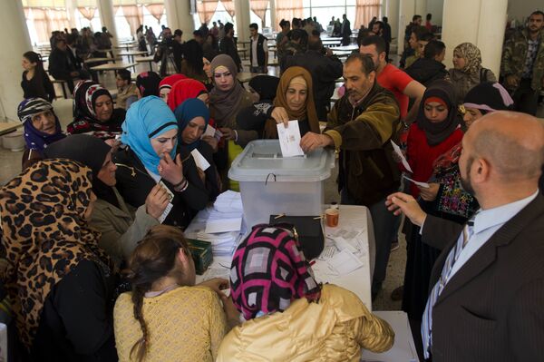 A Syrian woman casts her vote at a polling station during the Syrian parliamentary election in Damascus, Syria. - Sputnik International