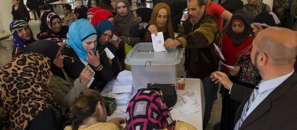 A Syrian woman casts her vote at a polling station during the Syrian parliamentary election in Damascus, Syria - Sputnik International