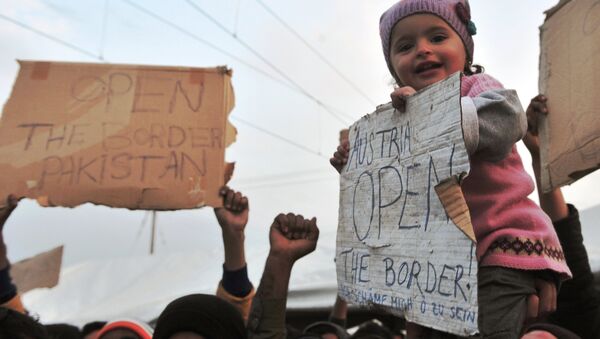A child is carried as she holds a banner reading Austria open the border! during a demonstration at the makeshift camp at the Greek-Macedonian border, near the Greek village of Idomeni on March 26, 2016. - Sputnik International