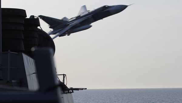An undated US Navy picture shows what appears to be a Russian Sukhoi SU-24 attack aircraft making a very low pass close to the U.S. guided missile destroyer USS Donald Cook in the Baltic Sea. - Sputnik International