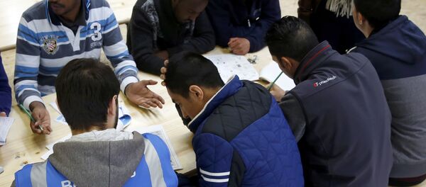 An assistant talks to a migrant in a Swiss Federal refugee center, set-up in a tank hall on the army base in Thun, Switzerland March 22, 2016 An assistant talks to a migrant in a Swiss Federal refugee center, set-up in a tank hall on the army base in Thun, Switzerland March 22, 2016 - Sputnik International