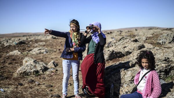 Members of the Syrian Kurdish Altay family try to spot from the Turkish Syrian border village of Mursitpinar, their relative, Zamani Suruc, who is fighting Islamic State (IS) jihadists in the Syrian border town of Kobane, also known as Ain al-Arab (File) - Sputnik International