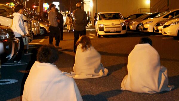 People wrapped in blankets sit on the road as they are evacuated from a hotel after an earthquake in Kumamoto, southern Japan, in this photo taken by Kyodo April 14, 2016 - Sputnik International