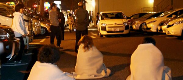 People wrapped in blankets sit on the road as they are evacuated from a hotel after an earthquake in Kumamoto, southern Japan, in this photo taken by Kyodo April 14, 2016 People wrapped in blankets sit on the road as they are evacuated from a hotel after an earthquake in Kumamoto, southern Japan, in this photo taken by Kyodo April 14, 2016 - Sputnik International