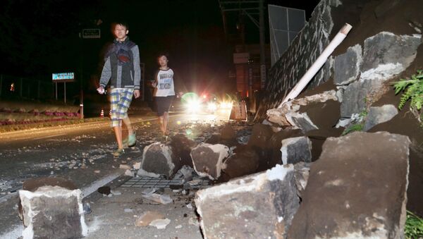 Local residents walk next to a collapsed wall after an earthquake in Mashiki town, Kumamoto prefecture, southern Japan, in this photo taken by Kyodo April 14, 2016 - Sputnik International
