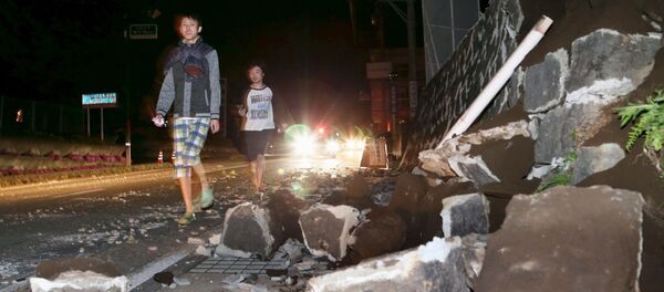 Local residents walk next to a collapsed wall after an earthquake in Mashiki town, Kumamoto prefecture, southern Japan, in this photo taken by Kyodo April 14, 2016 Local residents walk next to a collapsed wall after an earthquake in Mashiki town, Kumamoto prefecture, southern Japan, in this photo taken by Kyodo April 14, 2016 - Sputnik International