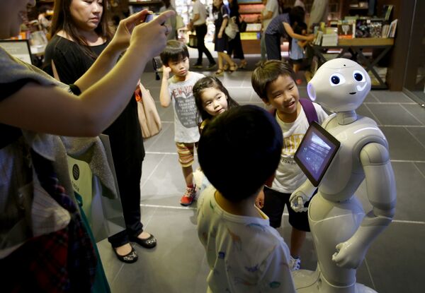 In this photo taken Sunday, July 12, 2015, children at a store in Tokyo try to talk with Pepper  - Sputnik International