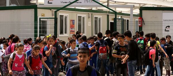 Displaced Iraqi Christian children gather outside a primary school at the Ashti camp for people who fled the violence in the northern city of Mosul after jihadists of the Islamic State (IS) group took control of the area, on April 12, 2016 in Arbil, the capital of the autonomous Kurdish region of northern Iraq - Sputnik International