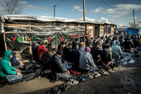 Men pray in the migrants and refugee camp in Calais, northern France. File photo Men pray in the migrants and refugee camp in Calais, northern France. File photo - Sputnik International