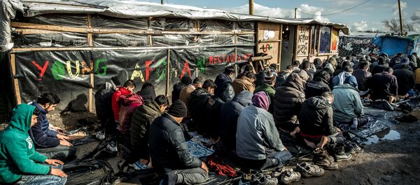 Men pray  in the migrants and refugee camp in Calais, northern France. File photo - Sputnik International