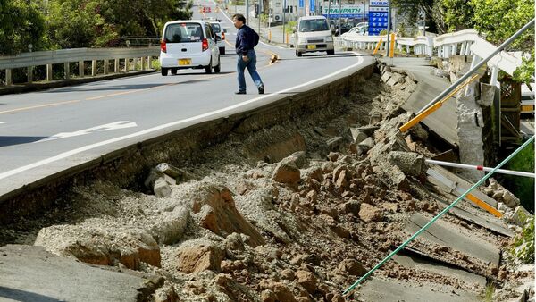 A man walks near a damaged road caused by an earthquake in Mashiki town, Kumamoto prefecture, southern Japan, in this photo taken by Kyodo April 15, 2016 - Sputnik International