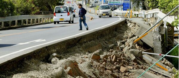 A man walks near a damaged road caused by an earthquake in Mashiki town, Kumamoto prefecture, southern Japan, in this photo taken by Kyodo April 15, 2016 - Sputnik International