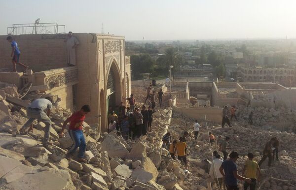 People walk on the rubble of the destroyed Mosque of The Prophet Younis, or Jonah, in Mosul, 225 miles (360 kilometers) northwest of Baghdad, Iraq (File) - Sputnik International