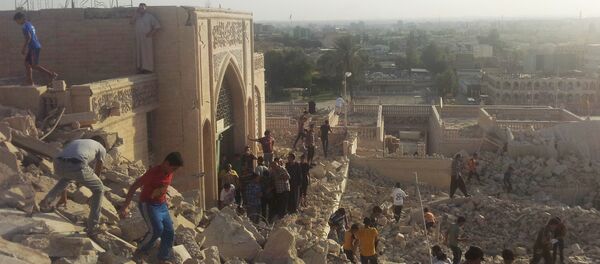 People walk on the rubble of the destroyed Mosque of The Prophet Younis, or Jonah, in Mosul, 225 miles (360 kilometers) northwest of Baghdad, Iraq (File) - Sputnik International