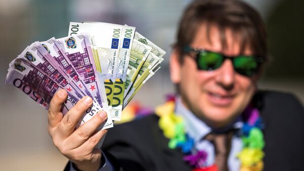 An activist shows fake banknotes during a demonstration outside the European Commission (EC) headquarters ahead of statements by the EC on the effectiveness of existing measures against tax evasion and money-laundering in light of the recent Panama Paper revelations, in Brussels, Belgium, April 12, 2016 - Sputnik International