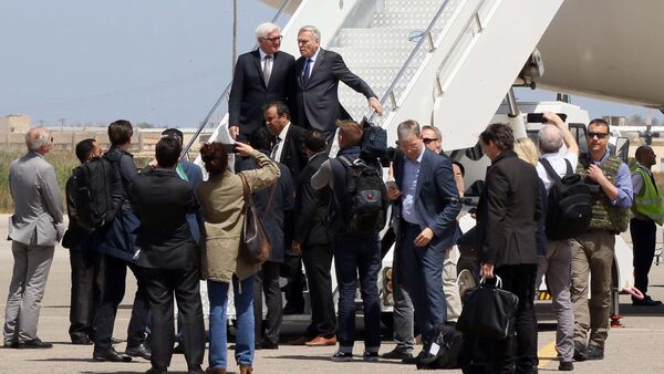 French Foreign affairs minister Jean-Marc Ayrault (top-R) and German Foreign Minister Frank-Walter Steinmeier (top-L) disembark from the plane upon their arrival in the Libyan capital, Tripoli on April 16, 2016 - Sputnik International