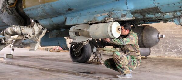A Syrian Army soldier attaches a missile to a jet at Dmeir military airport, 50 km north-east of Damascus, on April 8, 2016 - Sputnik International