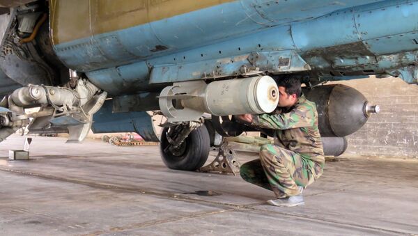 A Syrian Army soldier attaches a missile to a jet at Dmeir military airport, 50 km north-east of Damascus, on April 8, 2016 - Sputnik International