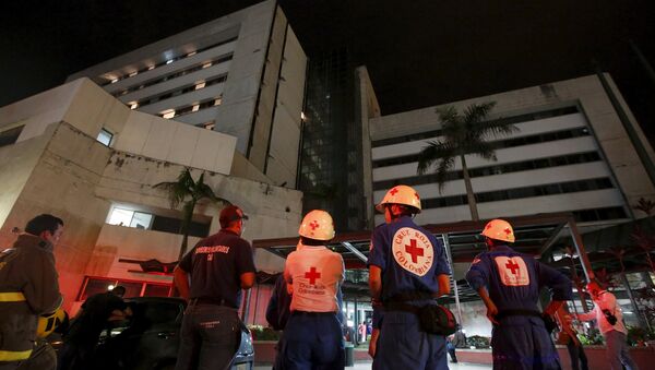 Rescue team members wait outside a clinic that was evacuated after tremors were felt resulting from an earthquake in Ecuador, in Cali, Colombia, April 16, 2016 - Sputnik International