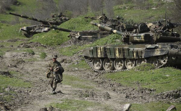 A soldier of the defense army of Nagorny Karabakh walks past tanks at a field position outside the village of Mataghis, some 70km north of Karabakh's capital Stepanakert, on April 6, 2016 A soldier of the defense army of Nagorny Karabakh walks past tanks at a field position outside the village of Mataghis, some 70km north of Karabakh's capital Stepanakert, on April 6, 2016 - Sputnik International