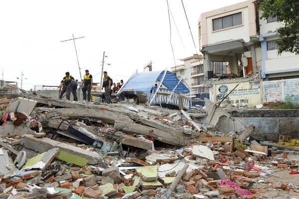 Police officers stand on debris after an earthquake struck off Ecuador's Pacific coast, at Tarqui neighborhood in Manta April 17, 2016 - Sputnik International