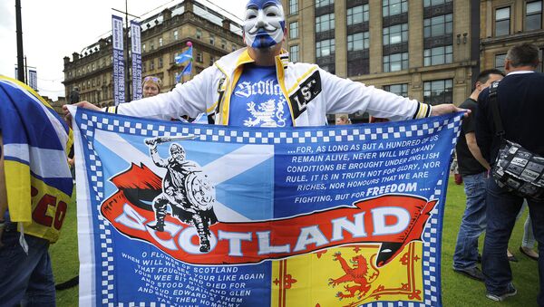 A pro Independence supporter wearing a Guy Fawkes mask bearing St Andrew's Cross holds a flag during a rally in George Square in Glasgow, Scotland (File) - Sputnik International