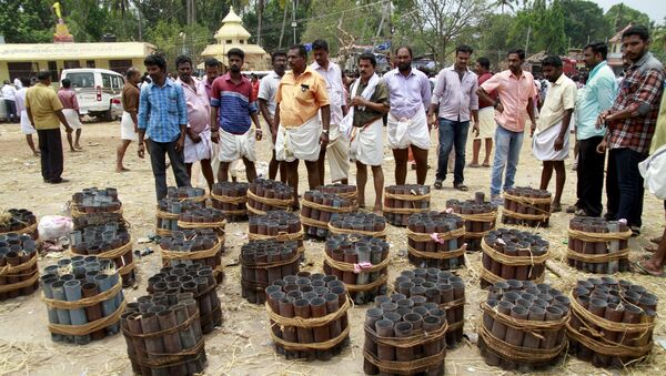 People stand next to empty fire cracker shells inside the compound of a temple after a fire broke out at the temple in Kollam in the southern state of Kerala, India, April 10, 2016. - Sputnik International