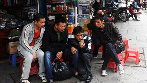 In this picture taken on December 5, 2014, men reads news from a smartphone on a commercial street in downtown Hanoi. - Sputnik International