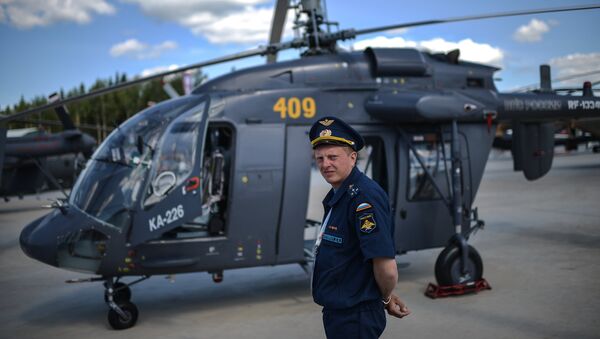 A pilot stands next to a Ka-226 helicopter at the ARMY-2015 international military technical forum held outside Moscow. - Sputnik International
