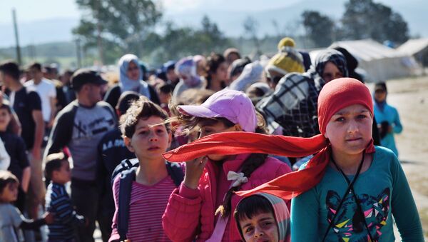 Refugees and migrants queue for food at the makeshift camp along the Greek-Macedonian border near the village of Idomeni on April 20, 2016. - Sputnik International