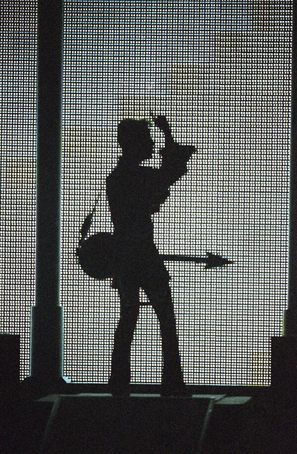 The artist formerly known as Prince, silhouetted with his guitar in front of a large television screen. The artist formerly known as Prince, silhouetted with his guitar in front of a large television screen. - Sputnik International