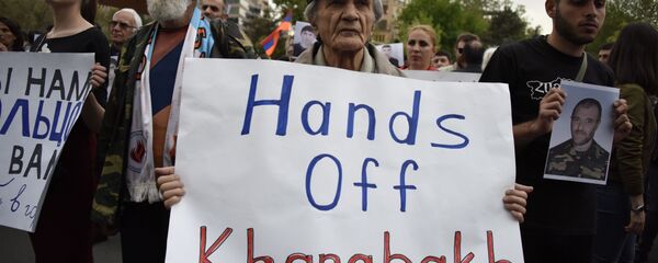 An Armenian man holds a placard reading Hands off Karabakh as he takes part in a rally in Yerevan on April 21, 2016. - Sputnik International