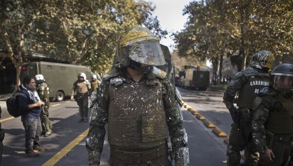 Riot police officers stands on the street after protesting students pelted them with paint during a protest demanding that the government make true its promise of free education, in Santiago, Chile, Thursday, April 21, 2016. - Sputnik International