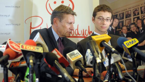 Poland's former Central Bank Governor Leszek Balcerowicz(L) speaks during a news conference before launching a public debt counter on a public screen in Warsaw on September 28, 2010 - Sputnik International