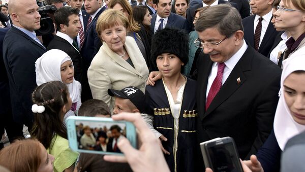 Turkish Prime Minister Ahmet Davutoglu and German Chancellor Angela Merkel pose for a picture with refugees in Nizip refugee camp near Gaziantep, Turkey, April 23, 2016 - Sputnik International