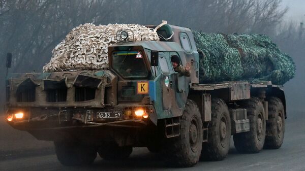 A Ukrainian soldier waves as troops with Smerch multiple launch rocket systems drive on a road not far from the eastern Ukrainian city of Kramatorsk in the Donetsk region on March 6, 2015 - Sputnik International