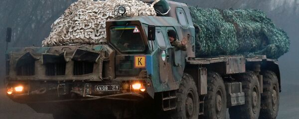 A Ukrainian soldier waves as troops with Smerch multiple launch rocket systems drive on a road not far from the eastern Ukrainian city of Kramatorsk in the Donetsk region on March 6, 2015 - Sputnik International
