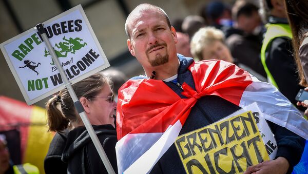 A demonstrator holds a placard reading rapefugees not welcome during a demonstration against Islamic terror organised by far-right movement Pegida Vlaanderen, on April 23, 2016, in Antwerp - Sputnik International