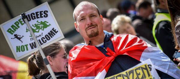 A demonstrator holds a placard reading rapefugees not welcome during a demonstration against Islamic terror organised by far-right movement Pegida Vlaanderen, on April 23, 2016, in Antwerp - Sputnik International